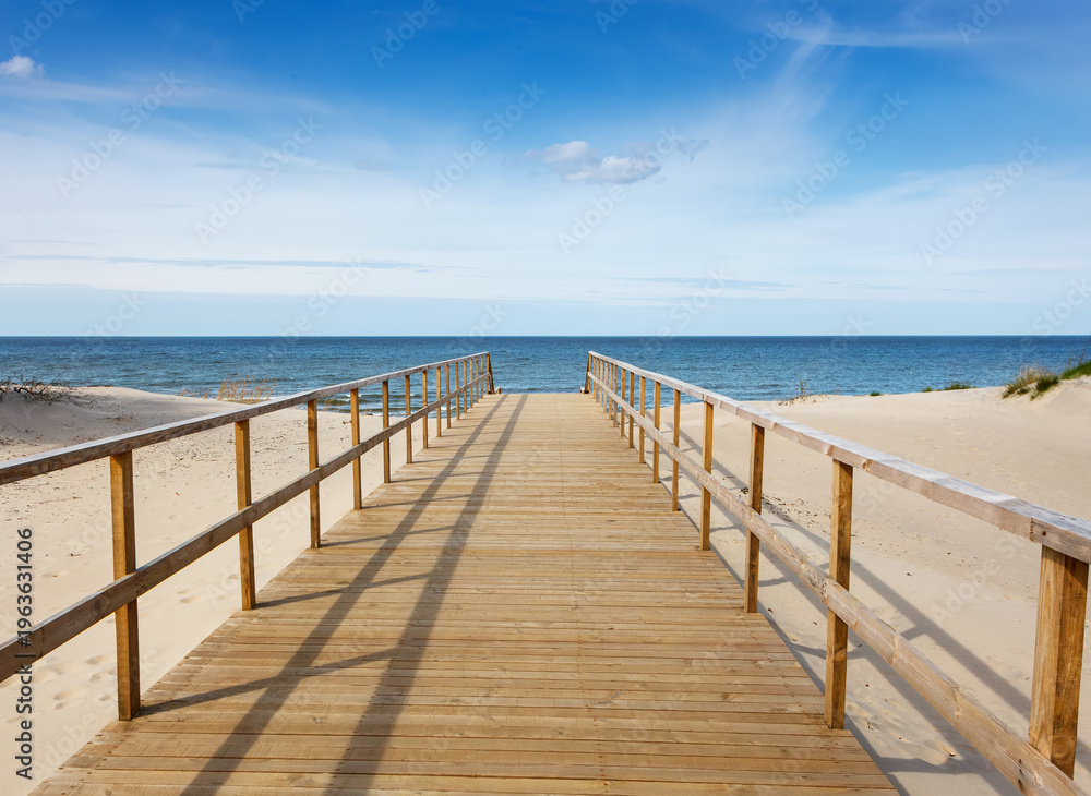 Fototapeta premium Wooden footpath going through a sand dune to the Baltic Sea