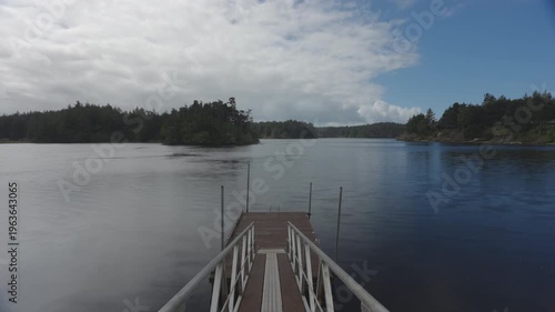 Dock on lake with clouds moving by
