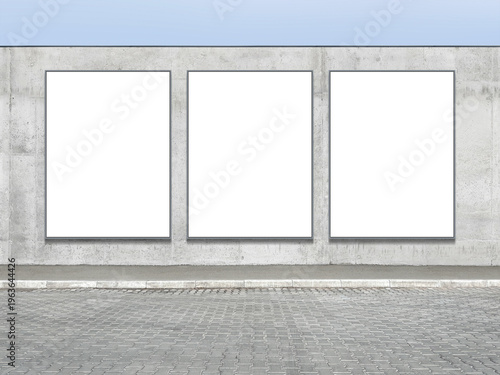 Three large vertical white advertising boards are placed on the facade of a concrete fence, intended for creative use. Presentation space. Advertising space.
