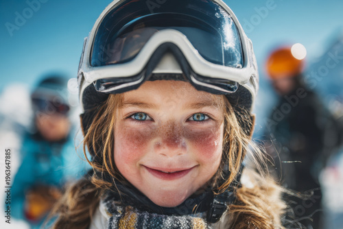 Smiling young girl in ski gear with bright blue eyes and rosy cheeks enjoying a sunny winter day on the snowy mountain slopes with friends in the background