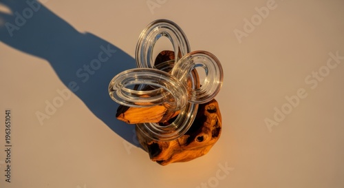 Contemporary glass sculpture on wooden base in natural light