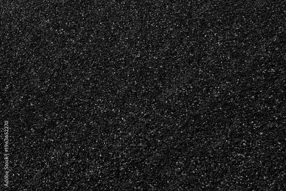 Fototapeta premium black surface fine sea pebbles is textured and uneven. Small stones and gravel are embedded in dark finish. Ideal background or design element.