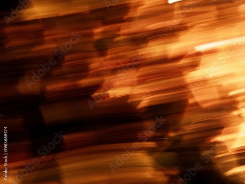 Abstract photo with warm orange and brown motion blur and light streaks. Dynamic horizontal lines create a vibrant and energetic background.