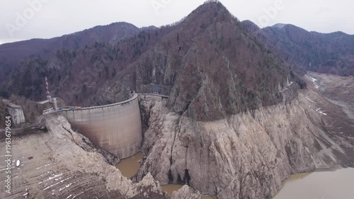 Low water level at Vidraru Dam in the Carpathian Mountains on a cloudy day