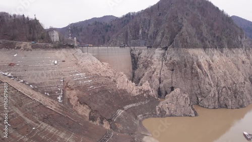 Low water level at Vidraru Dam in the Carpathian Mountains on a cloudy day