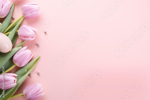 Pink tulips and an easter egg decorating a pastel pink background with small silver beads
