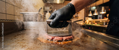 Chef pressing smash burger on hot grill with steam