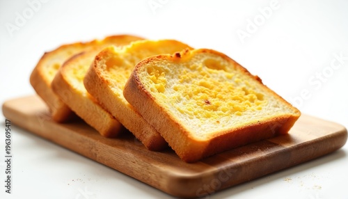 Golden toasted bread slices sit on a wooden board. The crust is crisp and inviting. This simple food photo is perfect for recipes and breakfast.