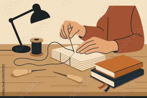 Hands carefully stitching pages together to create a handmade notebook with thread and needle