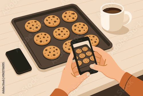 Hands photographing freshly baked chocolate chip cookies on a baking sheet with a smartphone