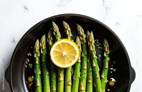 Fresh green asparagus spears arranged in black pan with lemon slice. Healthy vegetable ingredients cooked with oil and spices. Delicious vegetarian meal prep.