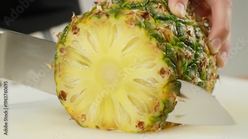 Wallpaper Mural Extreme close-up, slow-motion video of golden-yellow pineapple meticulously sliced by a chef's knife on a white board, arranged on glass, soft daylight, creamy bokeh background. Concept of vibrant Torontodigital.ca