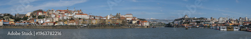 Panoramic view of Porto riverside cityscape with colorful houses and historic architecture by Douro river