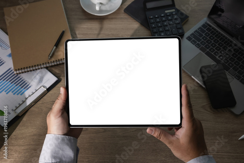 Digital tablet mockup in an office workspace with blank screen for app design, business presentation, finance dashboard, analytics display, marketing report and branded content.