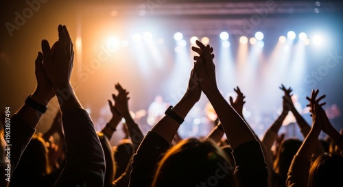 Enthusiastic crowd clapping hands at a concert hall