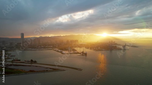 Aerial drone sunset view of Izmir Alsancak Port, a major commercial seaport in Turkey, with cargo cranes and city skyline