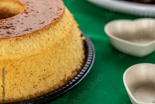 Close-up de bolo pudim com cobertura de caramelo em prato sobre mesa verde