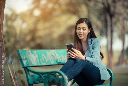 Asian woman smartphone park...