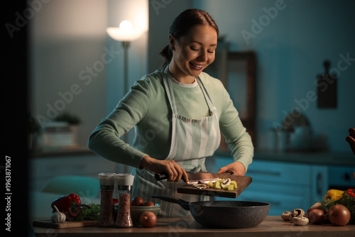 Young woman putting cut veg...