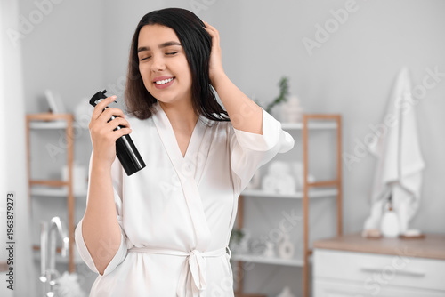 Young woman with hair spray...