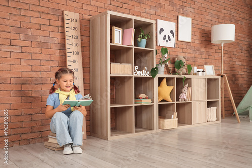 Little girl reading book ne...