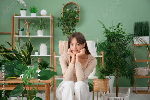 Young female gardener sitti...