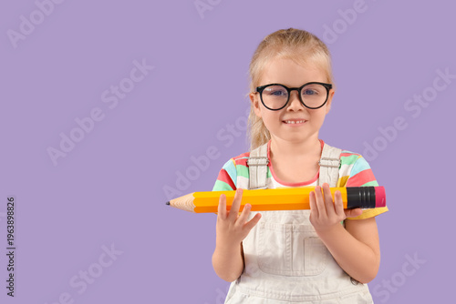 Cute little schoolgirl with big pencil on lilac background