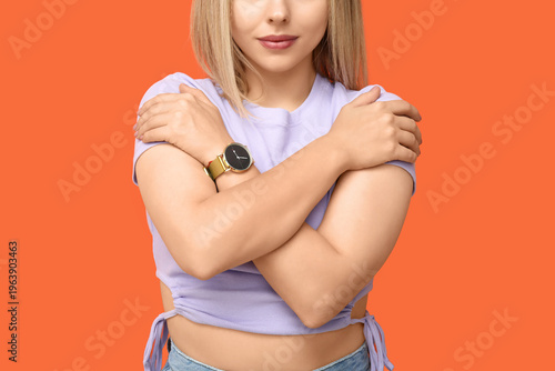Young woman hugging herself...