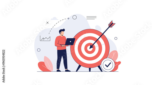 Professional man using a laptop standing next to a giant bullseye target with an arrow in the center for success.