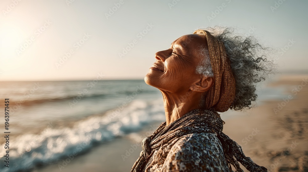 Obraz premium A serene senior woman enjoying a peaceful moment at the beach during sunset