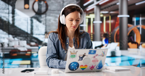 Obraz na płótnie Focused Woman With Headphones Engaged In Online Learning Using Laptop