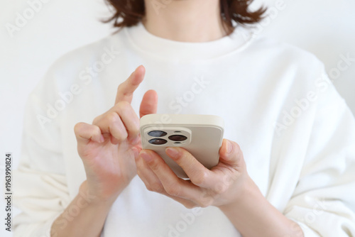 スマートフォンを操作する女性の手元