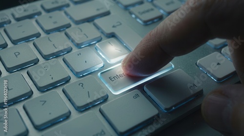 Close Up Of Finger Pressing Enter Key On Illuminated Computer Keyboard For Cyber Access
