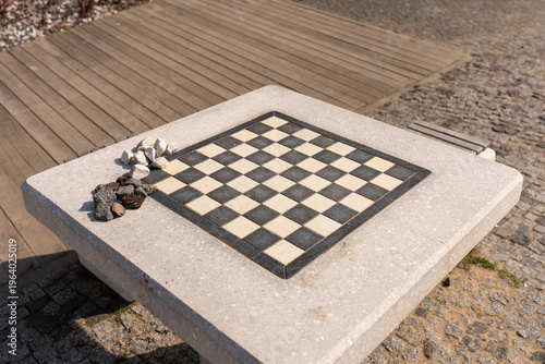 Canvastavla A close-up of a concrete outdoor chess table with small white and dark stones us