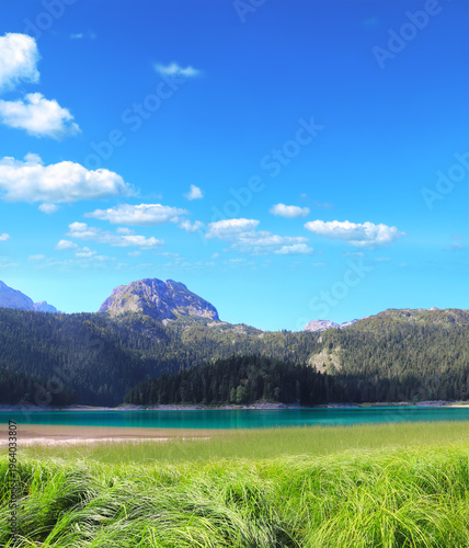 Picturesque view of Black Lake, Zabljak province, Durmitor National Park, Montenegro. Beautiful scene with lake in mountains and Bobotov Kuk peak. Topic of summer vacation, travel, cruises and tours