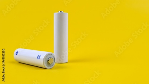 Cuadro en lienzo White metal AA-size batteries isolated on yellow background.