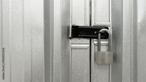 Принти на полотні Silver padlock securing a black metal latch on corrugated steel