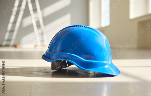 Hardhat helmet for safety and construction protection. Blue helmet on a bright floor, suggesting renovation, engineering and site compliance. Clear message of safety equipment and workwear.