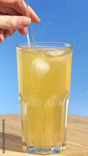 Healthy flavored fresh sparkling kombucha is stirred with a glass straw, and taken. Iced fizzy drinks, and summer vibes.