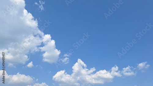 Clear vibrant blue sky with beautiful white fluffy clouds on sunny day