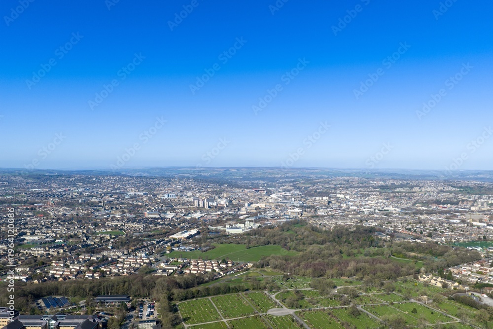 Obraz premium Aerial view of a large cemetery in Bradford West Yorkshire with gravestones pathways and surrounding residential housing captured from above in natural daylight in the early spring season