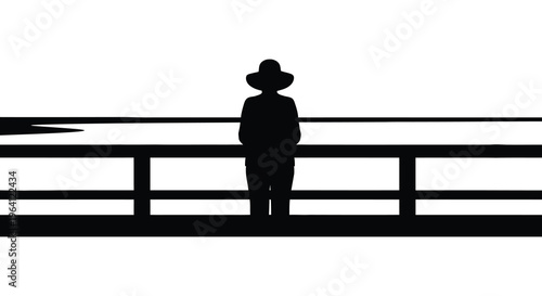 A lone figure stands by a railing gazing at the water silhouette