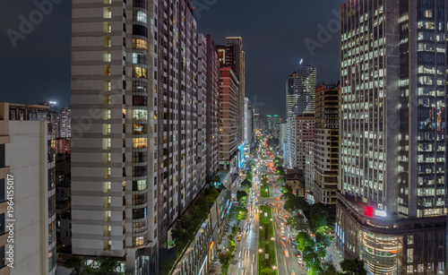 Photos Night view of Le Van Luong Street with illuminated high-rise buildings and busy traffic lines stretching into the distance