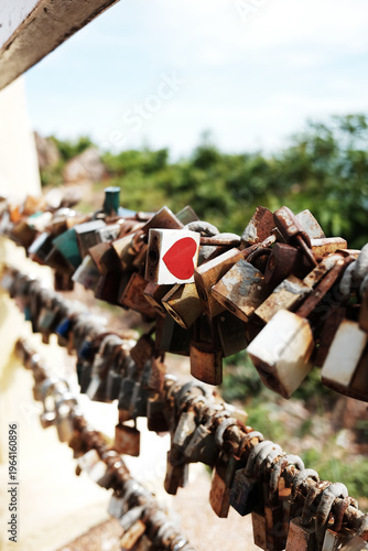 Close up red heart shape on Padlock old keys rusty lock on the wire for lovers at the view point