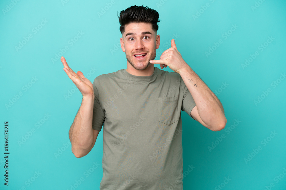 Fototapeta premium Young caucasian man isolated on blue background making phone gesture and doubting