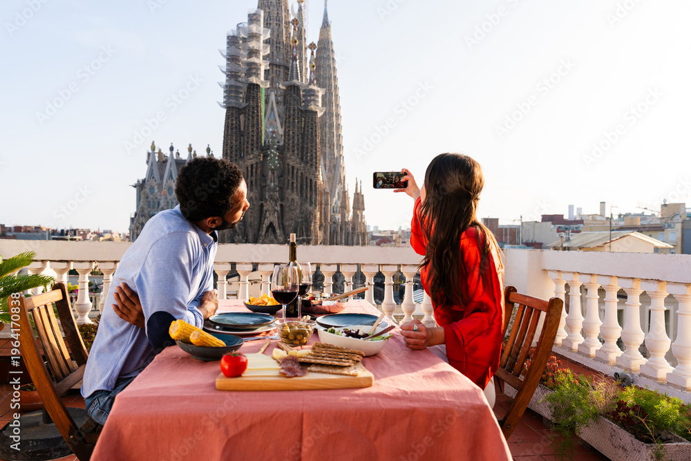 Naklejka premium Multiracial beautiful happy couple of lovers dating in Barcelona on a rooftop with amazing city view
