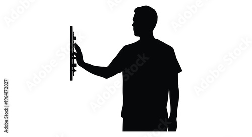 Man reaching for a light switch depicted in stark black silhouette