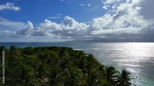 Aerial drone footage of Ilet du Gosier island near Pointe-à-Pitre, Guadeloupe. Scenic tropical landscape with white sandy beach, turquoise Caribbean Sea and iconic lighthouse. Popular travel destinati