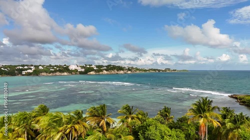 Aerial drone footage of Ilet du Gosier island near Pointe-à-Pitre, Guadeloupe. Scenic tropical landscape with white sandy beach, turquoise Caribbean Sea and iconic lighthouse. Popular travel destinati