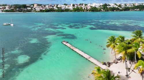  Aerial drone footage of Ilet du Gosier island near Pointe-à-Pitre, Guadeloupe. Scenic tropical landscape with white sandy beach, turquoise Caribbean Sea and iconic lighthouse. Popular travel destinat
